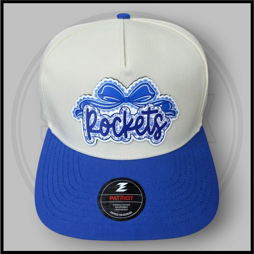 Cream and blue baseball cap with large blue script logo patch and Patriot badge