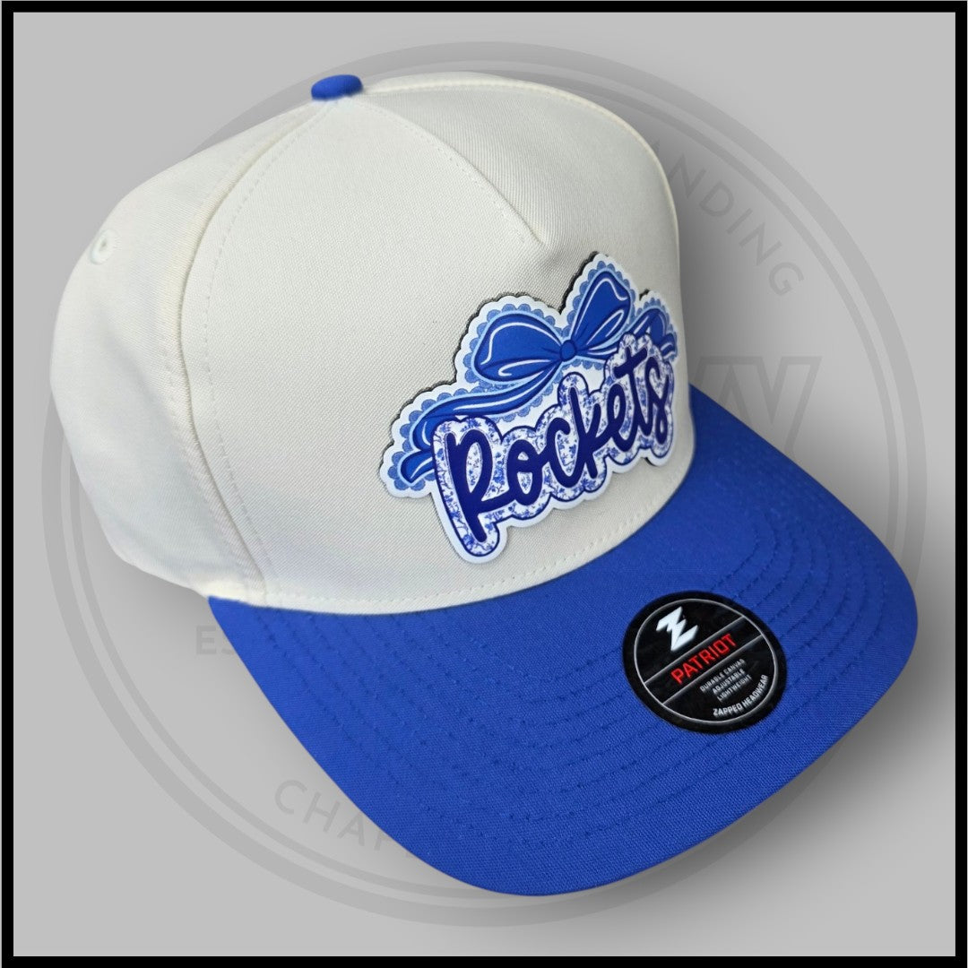 Cream crown and blue brim baseball cap with blue script logo patch and Patriot badge
