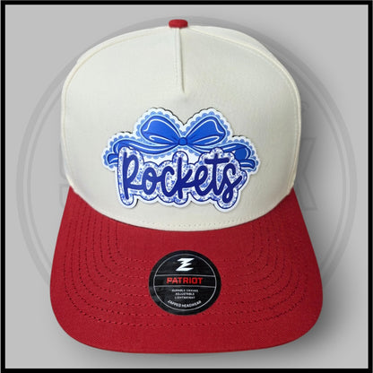 Cream and red baseball cap with large blue script logo patch and Patriot badge