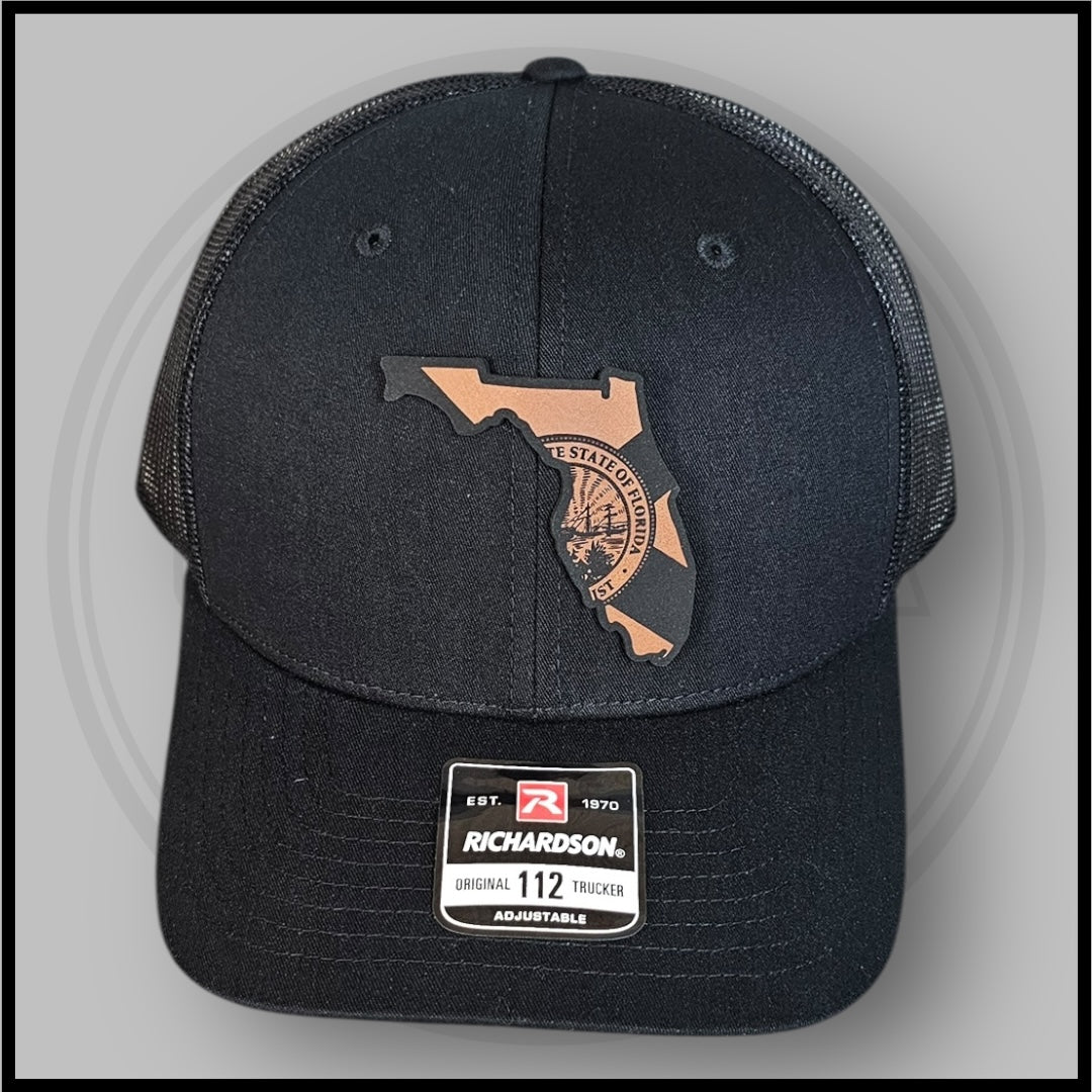 Black Richardson trucker cap front view with Florida outline state seal and size tag