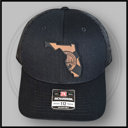 Black Richardson trucker cap front view with Florida outline state seal and size tag