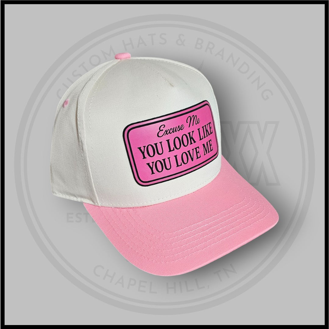 White and pink trucker cap with front patch reading 'Excuse Me' and 'You Look Like You Love Me'