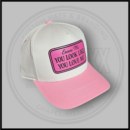 White and pink trucker cap with front patch reading 'Excuse Me' and 'You Look Like You Love Me'
