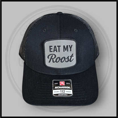 Dark charcoal trucker baseball cap with front Eat My Roost oval patch and Richardson label