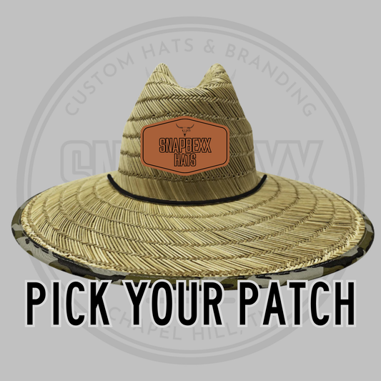 Wide brim straw hat with black band and rectangular patch on crown