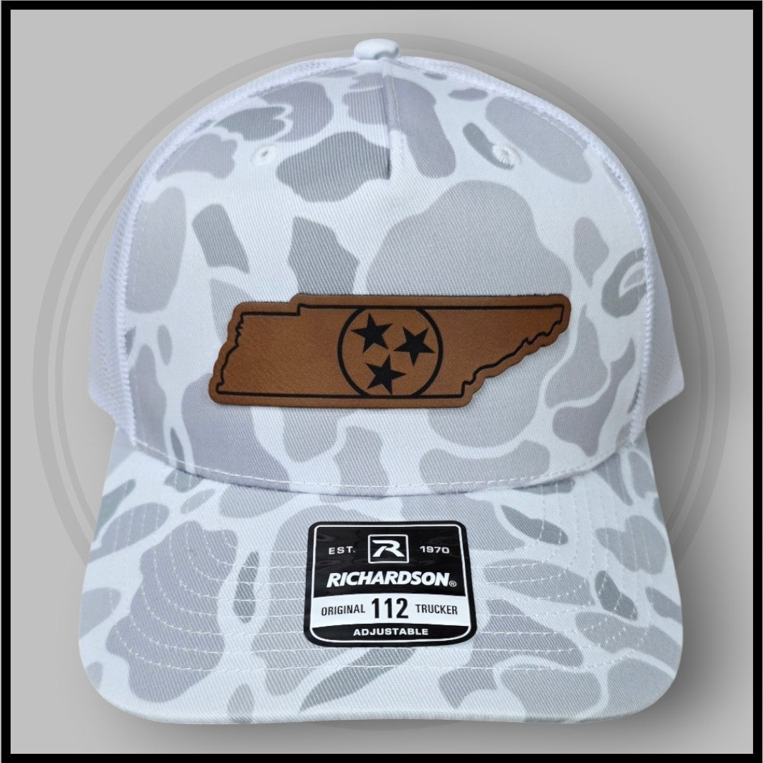 White duck camo trucker cap with brown logo patch and adjustable strap, mesh back
