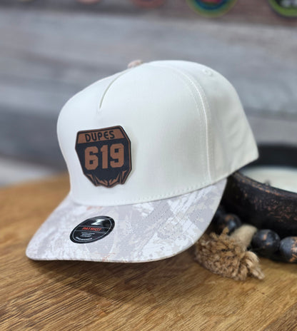 White baseball cap with 'Dupes 619' moto-plate patch and circular logo patch